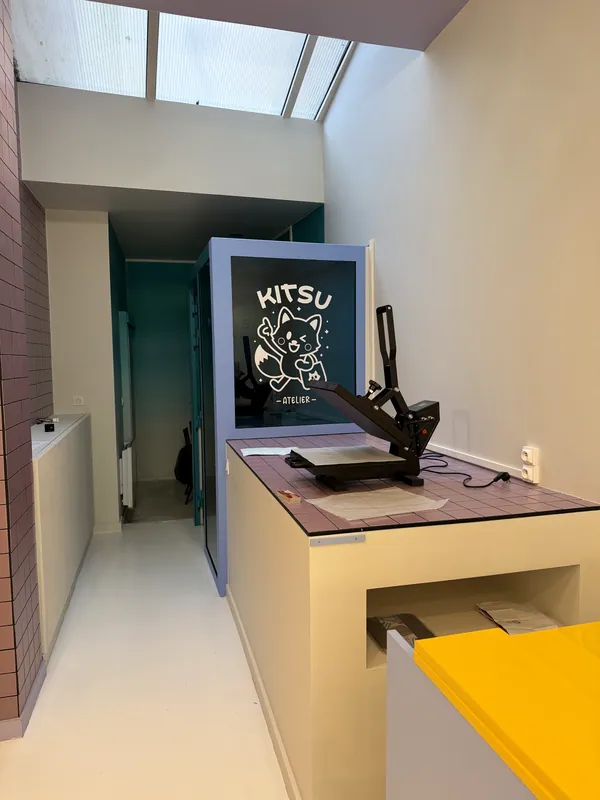 L'intérieur de l'atelier : le comptoir et la presse à chaud où sont posés les écussons
