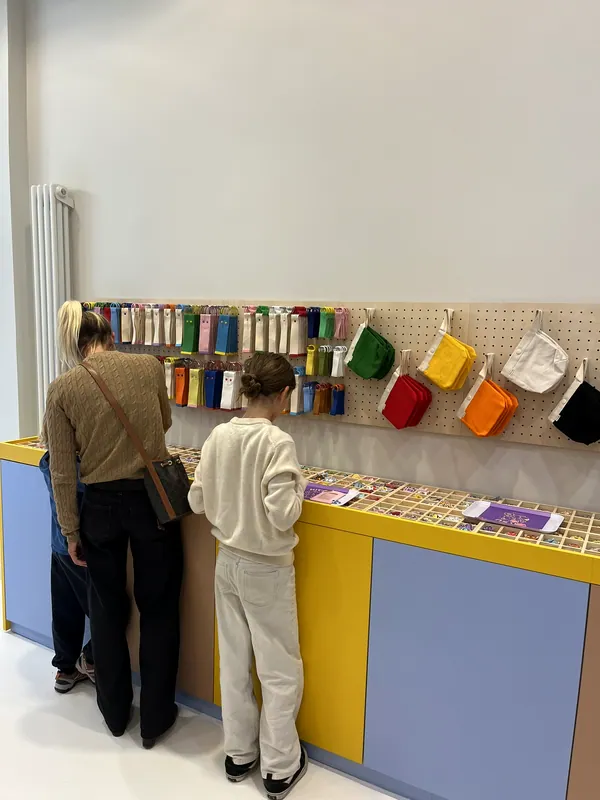Des clients composent leur création devant les boîtes d'écussons du grand comptoir