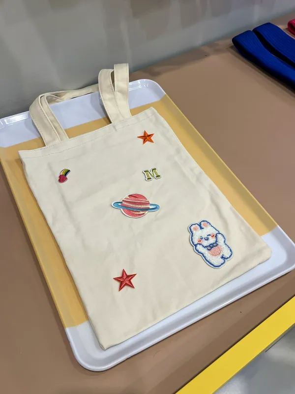 Tote bag écru décoré de planètes, étoiles et lettre brodée